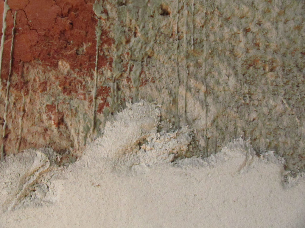 Fig.27. Detalhe da mesma parede, onde se podem ver partes da taipa sem revestimento (cor de argila), partes chapiscadas (escuras) e partes já rebocadas (claras) (fonte: acervo DPH/STPRC, 2011).